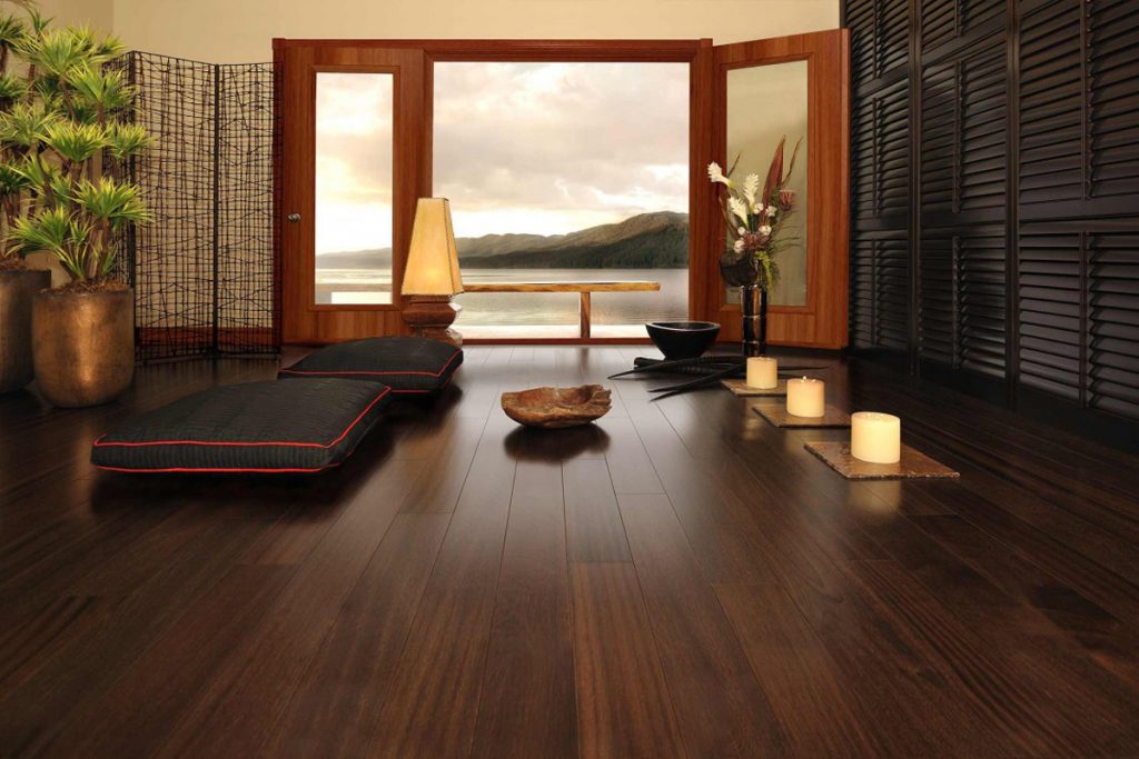 A room with a view of the ocean and a bowl on the floor.