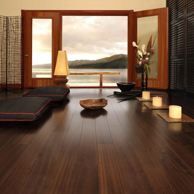 A room with a view of the ocean and a bowl on the floor.