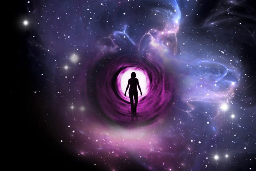 A person is standing in the center of a purple nebula.